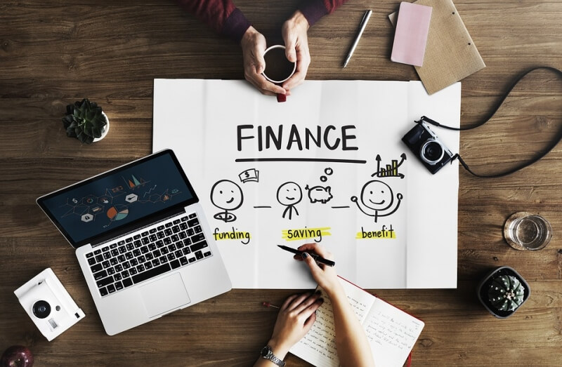 Finance poster with laptop on a wooden desk