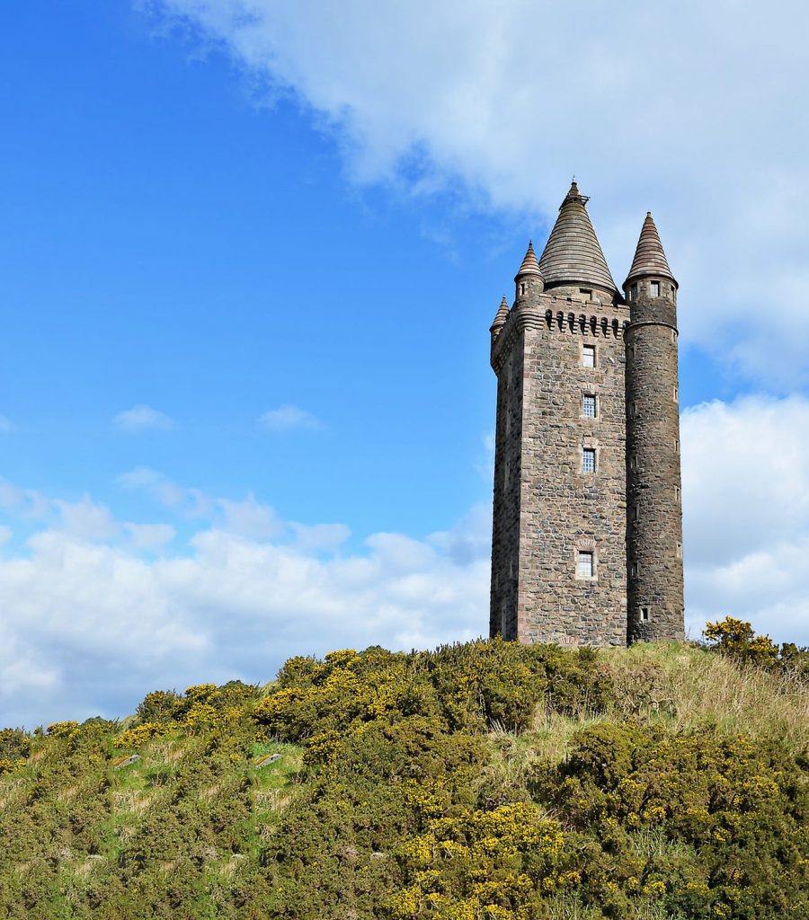 Stone tower with green grass and blue sky