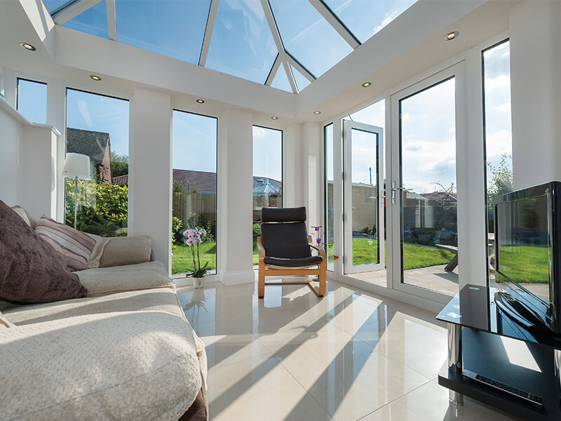 Inside a white modern conservatory with glass roof.