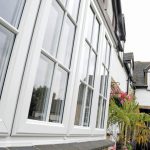 Exterior angled view white windows with astragal bars