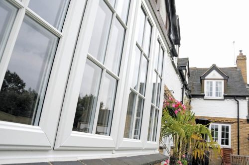 Exterior angled view white windows with astragal bars