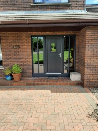 Black PVC windows and a composite door in grey.