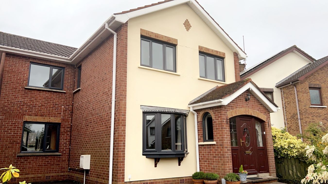 installation of grey windows on a brick house with cream facade