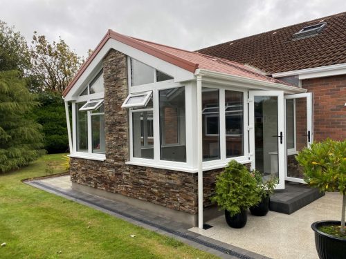 ultraroof upvc conservatory extension with opened white upvc french doors